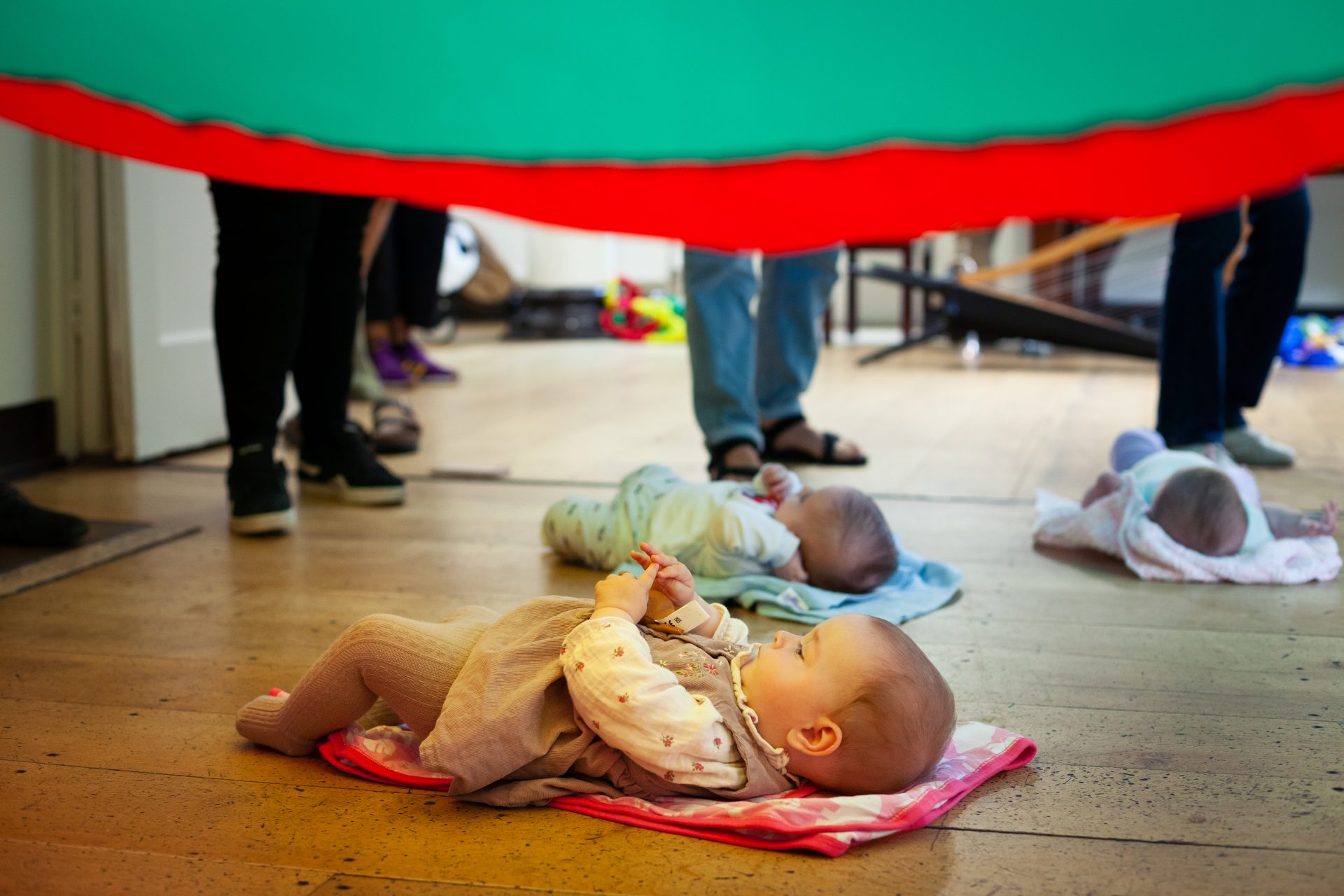 Baby lying under play parachute at Mini Mozart Music Class for babies and toddlers at Crouch End Picturehouse
