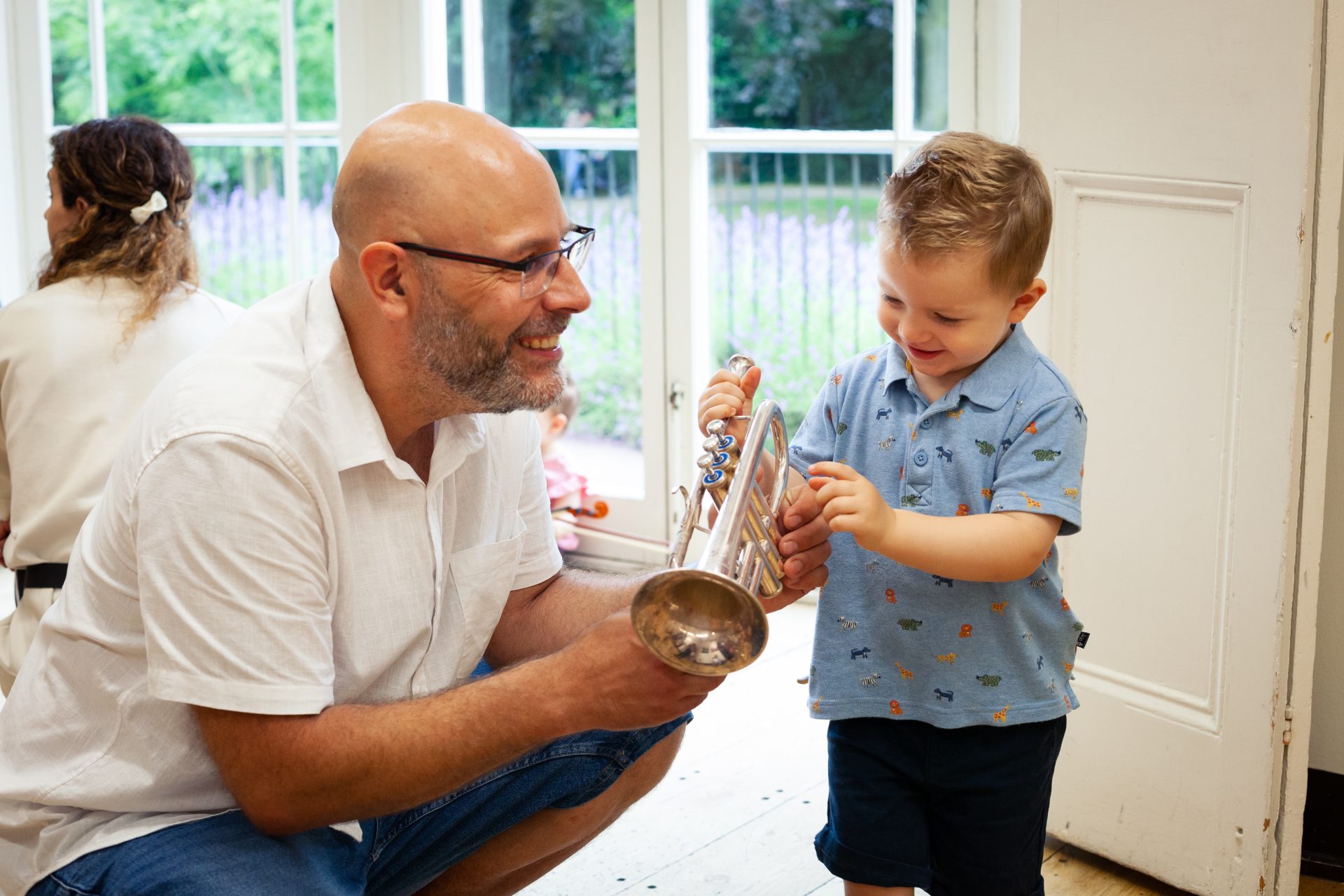 Father and son explore the trumpet at a Mini Mozart music class for babies and toddlers
