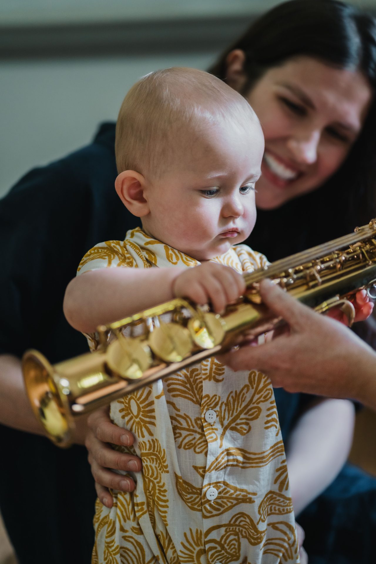 Mother and baby bond over discovering the saxophone together at a Mini Mozart Music Class for babies and toddlers