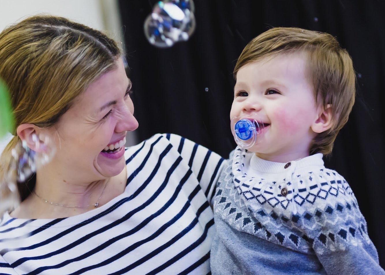 Smiling mum and baby enjoy bubble play at a Mini Mozart music class for babies and toddlers