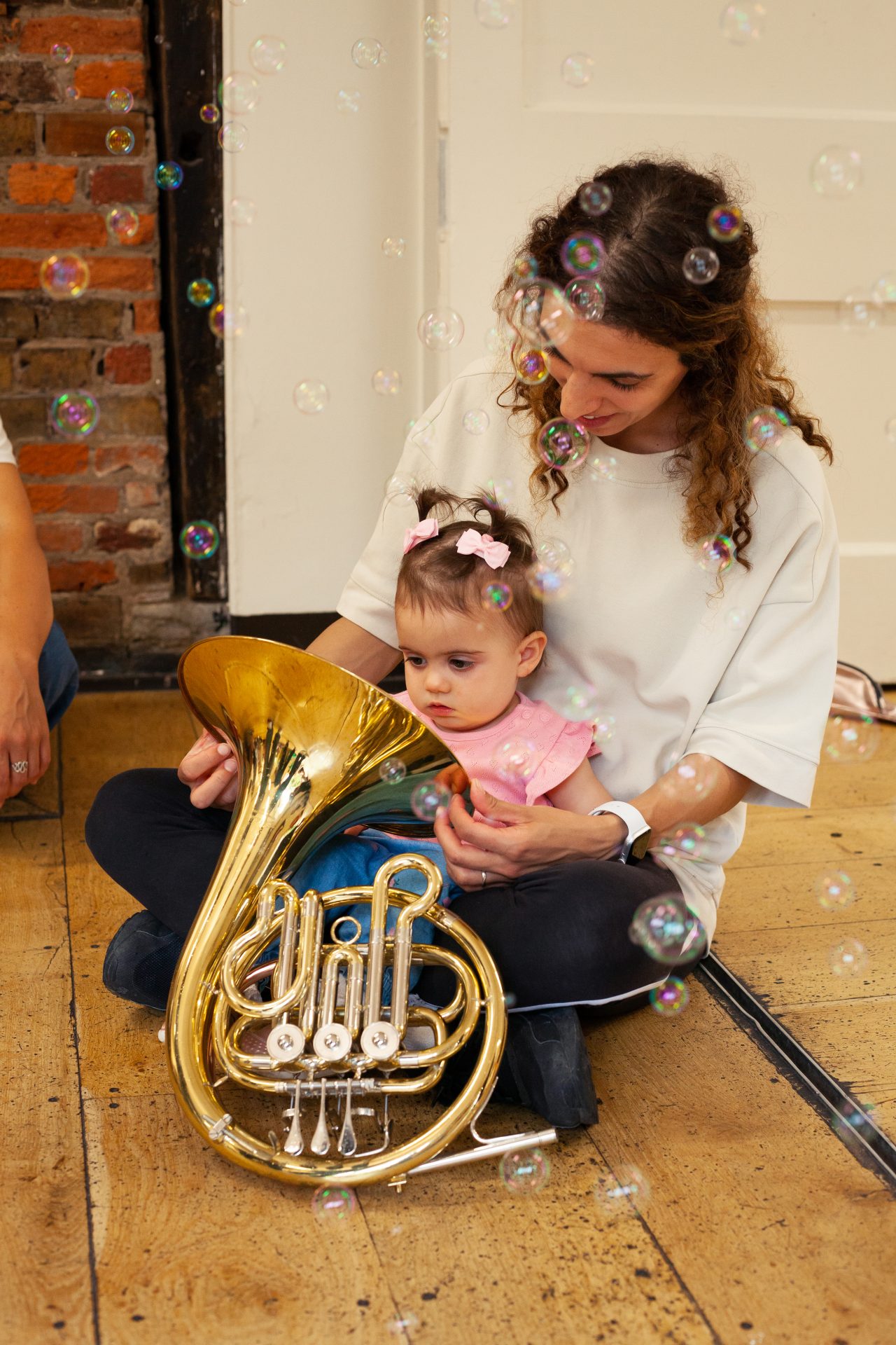 Mother and daughter explore the French Horn together at a Mini Mozart music class for babies and toddlers