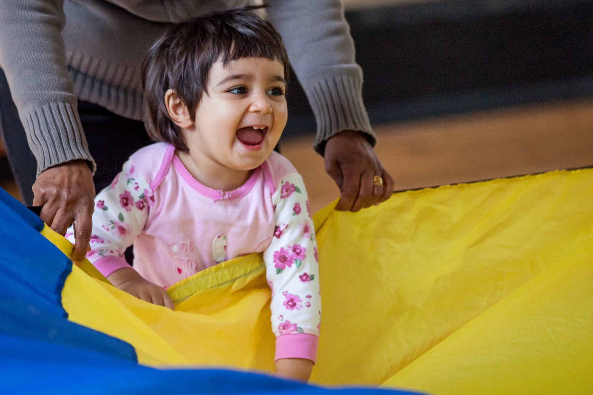 Toddler having fun with the parachute at a Mini Mozart music class for babies and toddlers